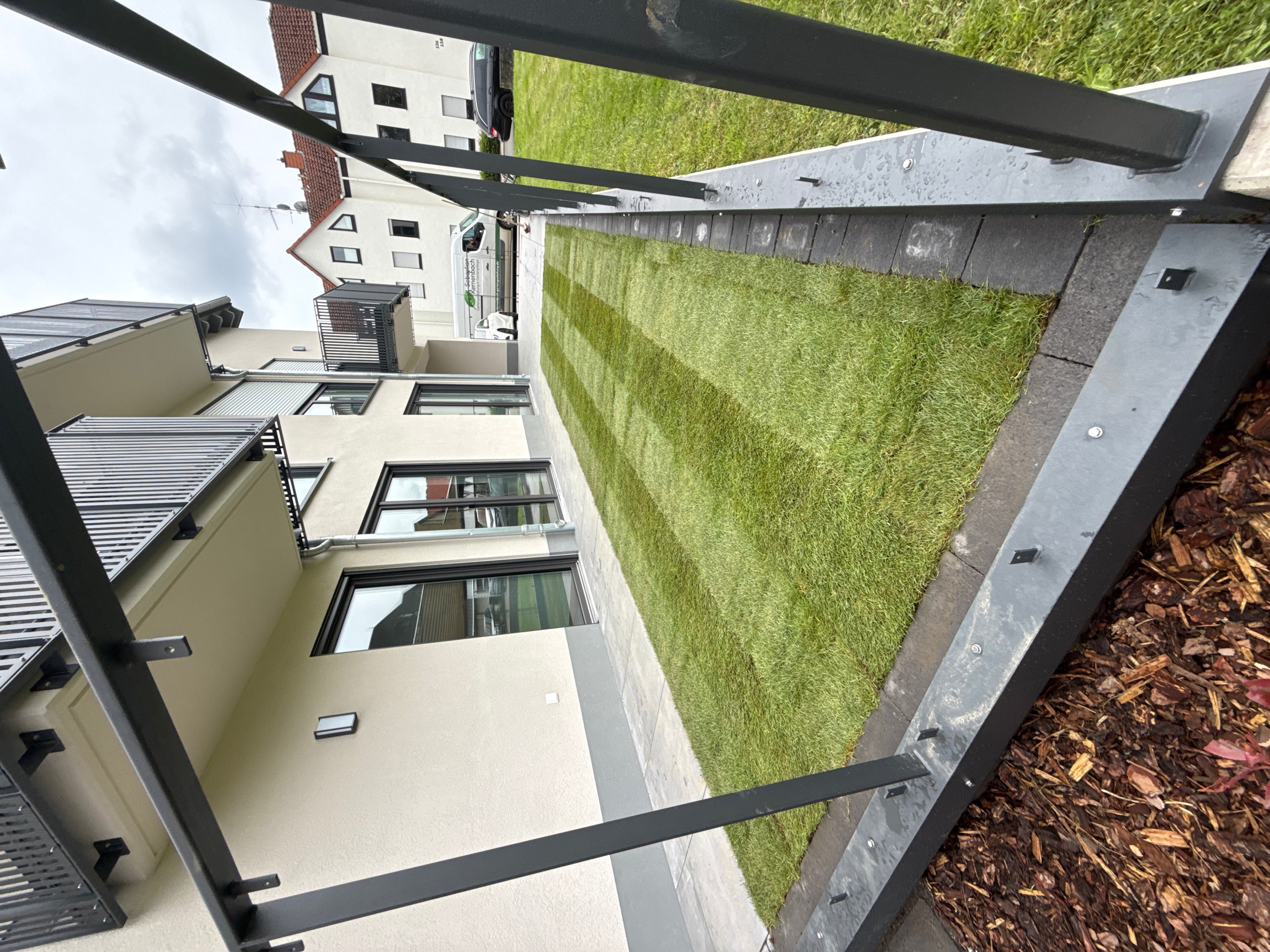 Rollrasen an Terrasse mit Rindenmulch-Beet