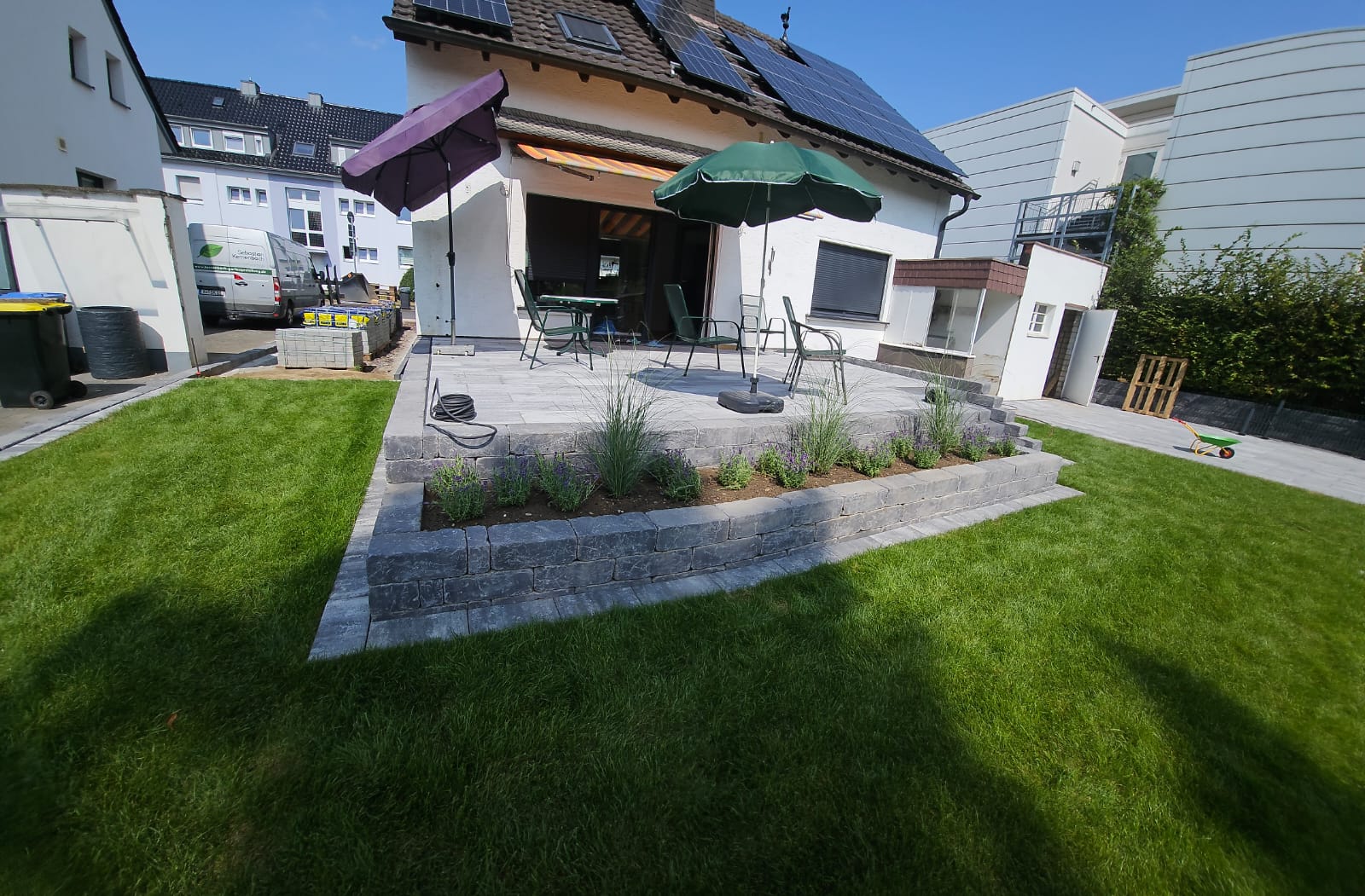 Fertiggestellte Gartenanlage mit Terrasse, Rasen und Natursteinmauer in Grafschaft